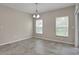 Bright dining area features neutral walls, stylish chandelier, tile floors, and natural light from two windows at 16016 Persimmon Grove Dr, Lithia, FL 33547