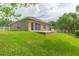 Manicured backyard featuring a brick patio, sliding glass doors, green grass, and a white picket fence at 20403 Sultana Ct, Tampa, FL 33647