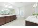 Bright bathroom featuring double vanities, a soaking tub, and modern fixtures at 20403 Sultana Ct, Tampa, FL 33647