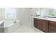 Modern bathroom with a walk-in shower, soaking tub, double vanity and tiled walls at 20403 Sultana Ct, Tampa, FL 33647