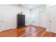 A well-lit, minimalist bedroom with hardwood floors and a dark wood accent cabinet at 20403 Sultana Ct, Tampa, FL 33647