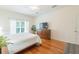 Airy main bedroom with hardwood floors, ceiling fan, large window, and a flat screen television at 20403 Sultana Ct, Tampa, FL 33647