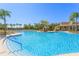A large community pool with lounge seating, tropical landscaping, stairs, and a clubhouse at 20403 Sultana Ct, Tampa, FL 33647