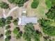 Aerial view of a home surrounded by a canopy of mature trees and a long driveway at 2205 Henley Rd, Lutz, FL 33558