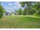 Large backyard with a shed, bordered by lush greenery and trees, offering a private and peaceful setting at 2205 Henley Rd, Lutz, FL 33558