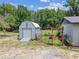 Features a shed with a ramp, complemented by lush greenery, plants, and garden art at 2205 Henley Rd, Lutz, FL 33558