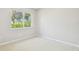 Bright bedroom with neutral walls, carpet, and a large window offering natural light and green view at 2205 Henley Rd, Lutz, FL 33558