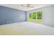 Spacious bedroom with big window overlooking a green yard at 2205 Henley Rd, Lutz, FL 33558