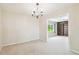 Light-filled dining area featuring carpet, chandelier, and view into a room with built-in shelving at 2205 Henley Rd, Lutz, FL 33558