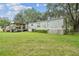 Exterior view of a manufactured home, showcasing a large yard and wooden deck at 2205 Henley Rd, Lutz, FL 33558