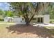 Charming house with a shaded porch, a detached shed, and a mature tree in the yard at 2205 Henley Rd, Lutz, FL 33558