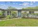 Inviting home exterior with a light blue front door, stone walkway, and lush landscaping at 2205 Henley Rd, Lutz, FL 33558