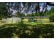Charming single-story home with a well-manicured lawn, mature trees, and a welcoming blue front door at dusk at 2205 Henley Rd, Lutz, FL 33558