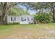 Charming home with a well-maintained front lawn, mature trees, and inviting entry steps at 2205 Henley Rd, Lutz, FL 33558
