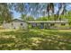 Charming single-story home with a well-manicured lawn, mature trees, and a welcoming blue front door at 2205 Henley Rd, Lutz, FL 33558