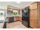 Kitchen featuring a black refrigerator, wood cabinets and tile flooring at 2205 Henley Rd, Lutz, FL 33558