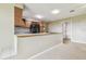 Kitchen with breakfast bar featuring dark cabinets, neutral countertops, and seamless transition to living area at 2205 Henley Rd, Lutz, FL 33558