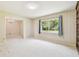 Cozy living room with a large window offering natural light, adjacent to a dining area, and carpet flooring at 2205 Henley Rd, Lutz, FL 33558
