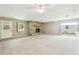 Living room featuring stone fireplace, neutral carpet, and access to the exterior with abundant natural light at 2205 Henley Rd, Lutz, FL 33558