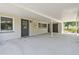 Spacious covered patio with concrete flooring, entry doors, and a view of the backyard at 2205 Henley Rd, Lutz, FL 33558