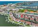 Aerial view of coastal community featuring waterfront condos, community pool, and recreational sports park at 230 Medallion Blvd # F, Madeira Beach, FL 33708
