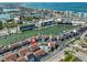 Aerial view of townhouse complex with red roof, canal access, and a community pool; a great location! at 230 Medallion Blvd # F, Madeira Beach, FL 33708