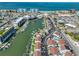 Stunning aerial view showcases waterfront condos with private boat slips, a canal, and ocean views beyond the city at 230 Medallion Blvd # F, Madeira Beach, FL 33708