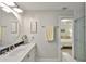 Bathroom featuring a modern vanity, decor, and walk-in shower with grey and white subway tiles at 230 Medallion Blvd # F, Madeira Beach, FL 33708