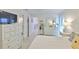 Bright bedroom features a white dresser, and views into the bathroom and hall at 230 Medallion Blvd # F, Madeira Beach, FL 33708