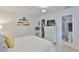 Bright bedroom featuring wood floors, a ceiling fan, and an adjacent bathroom at 230 Medallion Blvd # F, Madeira Beach, FL 33708