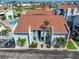 Charming building exterior with lush landscaping, palm trees and a parking area at 230 Medallion Blvd # F, Madeira Beach, FL 33708