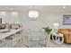 Open dining area with glass-top table, chairs, and a stylish chandelier at 230 Medallion Blvd # F, Madeira Beach, FL 33708