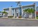 Condo exterior with blue accents, palm trees, and well-maintained landscaping for a tropical feel at 230 Medallion Blvd # F, Madeira Beach, FL 33708