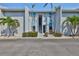 Condo exterior with blue accents, palm trees, and well-maintained landscaping for a tropical feel at 230 Medallion Blvd # F, Madeira Beach, FL 33708