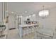 Modern kitchen with stainless steel appliances, breakfast bar seating, and stylish chandelier at 230 Medallion Blvd # F, Madeira Beach, FL 33708