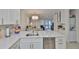 Bright kitchen with white cabinets, stainless steel appliances, and open floorplan at 230 Medallion Blvd # F, Madeira Beach, FL 33708