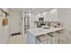 Modern kitchen with stainless steel appliances, quartz countertops, and breakfast bar seating at 230 Medallion Blvd # F, Madeira Beach, FL 33708