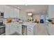Open concept kitchen and living area with white cabinets and stainless steel appliances at 230 Medallion Blvd # F, Madeira Beach, FL 33708