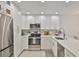 Bright kitchen with white cabinets, stainless steel appliances, and a marble backsplash at 230 Medallion Blvd # F, Madeira Beach, FL 33708