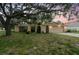 Charming single-story home with arched gate, front yard, and a mature tree in a beautiful residential setting at 2410 Covington Ave, Spring Hill, FL 34608