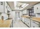 Galley kitchen with updated white cabinets, wood-look flooring and neutral countertops at 2410 Covington Ave, Spring Hill, FL 34608