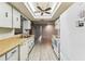 Kitchen with skylight, white cabinets, laminate countertops, and stainless sink at 2410 Covington Ave, Spring Hill, FL 34608