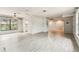 Large living room with wood-look floors, ceiling fans, and a glimpse into the kitchen at 2410 Covington Ave, Spring Hill, FL 34608