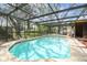 Refreshing pool enclosed within a screened lanai, offering a serene swimming experience at 2410 Covington Ave, Spring Hill, FL 34608