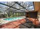 Relaxing screened pool surrounded by red mulch, perfect for outdoor enjoyment at 2410 Covington Ave, Spring Hill, FL 34608