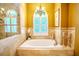Elegant bathroom featuring a soaking tub, chandelier, and travertine tile surround at 2417 Valrico Forest Dr, Valrico, FL 33594