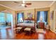 Spacious bedroom featuring hardwood floors, a four-poster bed, and ample natural light at 2417 Valrico Forest Dr, Valrico, FL 33594