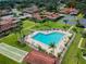 Aerial view showing community pool, shuffleboard court, carports and lush landscaping at 2444 Laurelwood Dr # A, Clearwater, FL 33763