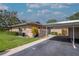 Exterior view with carport, manicured landscaping and green grass on a sunny day at 2444 Laurelwood Dr # A, Clearwater, FL 33763
