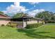 Tan home featuring a screened lanai and manicured landscaping with lush green lawn at 2444 Laurelwood Dr # A, Clearwater, FL 33763